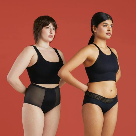 Two women wearing Thinx underwear in the color black.